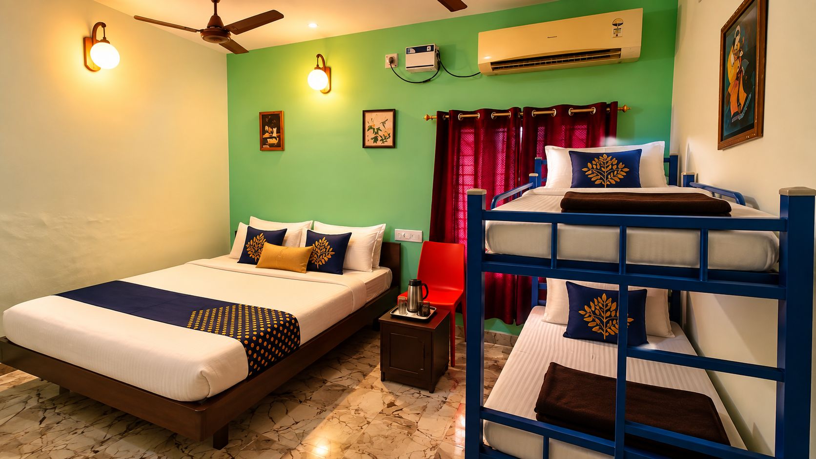 A hotel room with a bed, a bunk bed, a desk, a chair, and an air conditioning unit.