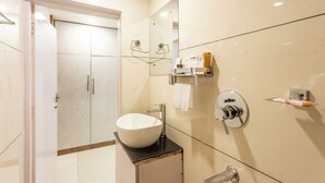 A modern bathroom with a large white sink, a mirror, and a towel rack.