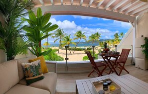 Ein gemütlicher Sitzbereich im Freien mit Blick auf Strand und Palmen.