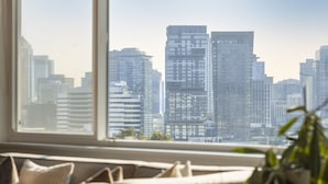 A modern living room with a large window overlooking a cityscape. - Artsy Capitol Hill Gem City View Workspace Parking (Seattle)