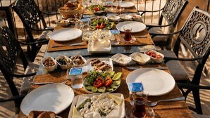 A table set for a meal with a view of a distant landscape, including a tower and dome structure.