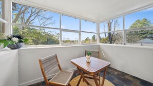 A conservatory with a table and chairs, large windows, and a potted plant. - Katoomba Getaway 1 -Perfectly positioned in a quiet, street just a hop, skip & jump to Katoomba town (Katoomba)