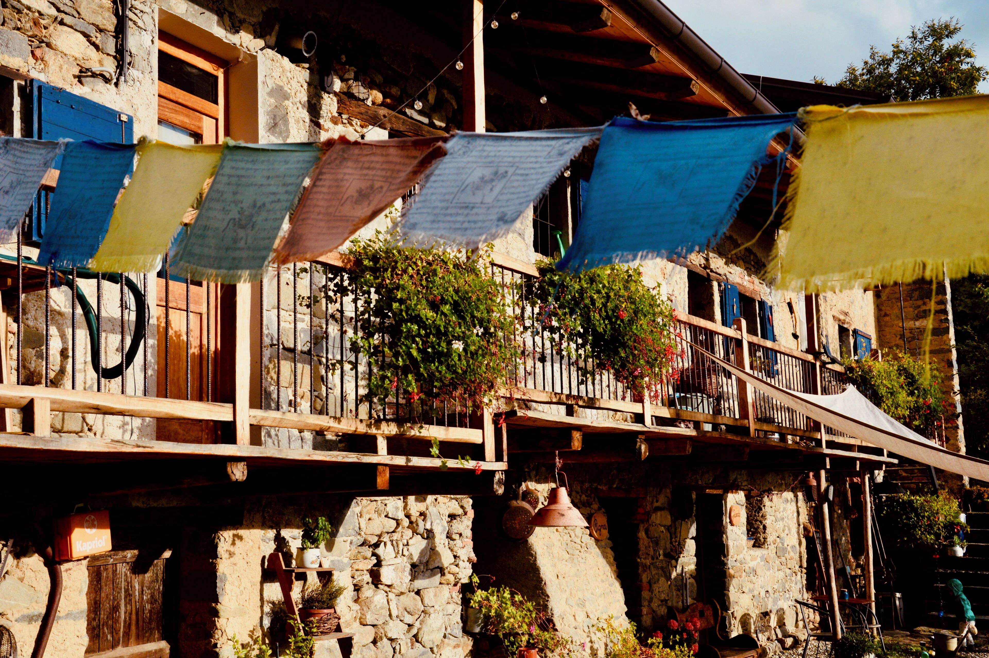 Un edificio in pietra con un balcone, piante in vaso e un cartello con la scritta 'Kastel'.