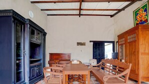 Une pièce spacieuse comprenant une table à manger en bois, des chaises, un canapé et un buffet.