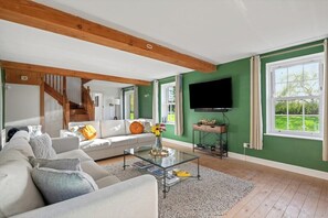 A living room with a sofa, coffee table, and TV. - Spacious 6-Bed Home Surrounded by Nature (Lincolnshire)
