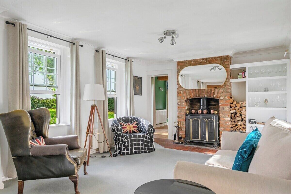 A living room with a fireplace, a sofa, a chair, and a lamp.