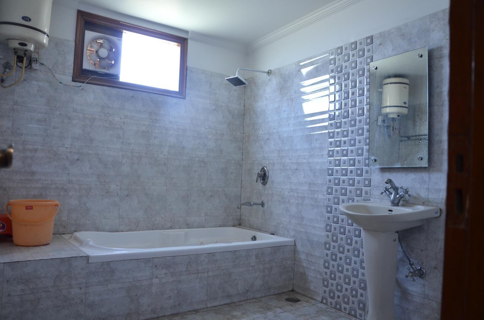Une salle de bain avec une baignoire, un lavabo et une fenêtre.
