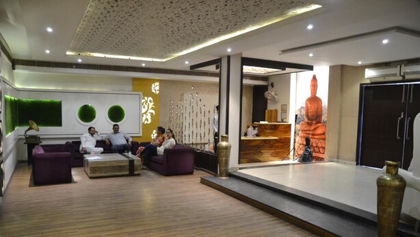Un vestíbulo moderno con mostrador de recepción, zona de estar y una estatua de Buda.