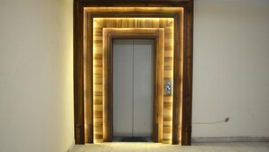 Puerta de ascensor con estructura de madera y panel iluminado.