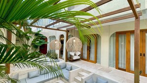 A modern indoor space with seating areas, a staircase, and decorative lighting.