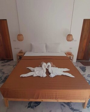 Ein Hotelzimmer mit einem Bett, zwei Nachttischen und einem Holzkopfteil.