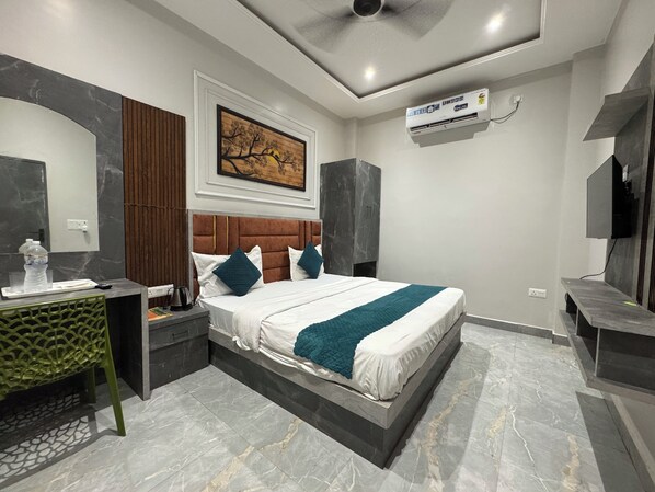 Un dormitorio moderno con una cama grande, una mesita de noche, un escritorio y un aire acondicionado instalado.