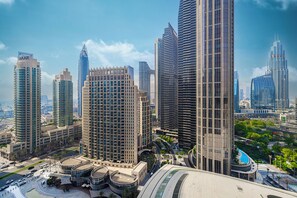 A high-rise urban area with modern skyscrapers, a central plaza with a circular building, and a curved structure with a pool. - Grande Suites by Hostiva - Burj View (Dubai)