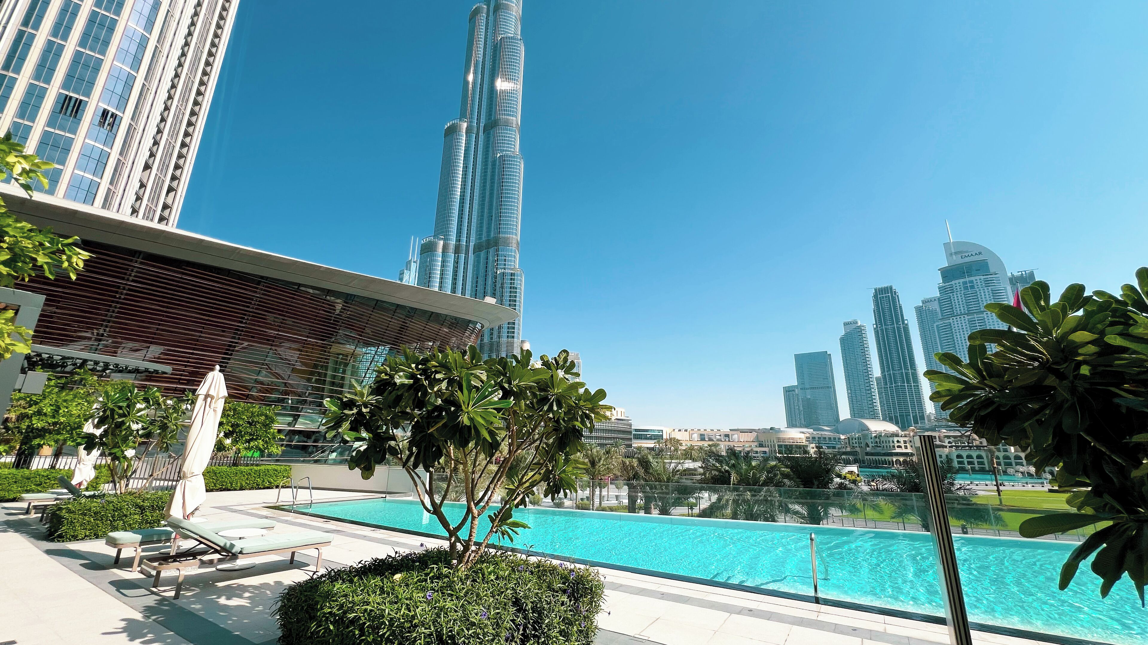 Zwembadgedeelte met ligbedden en uitzicht op de Burj Khalifa en andere wolkenkrabbers.