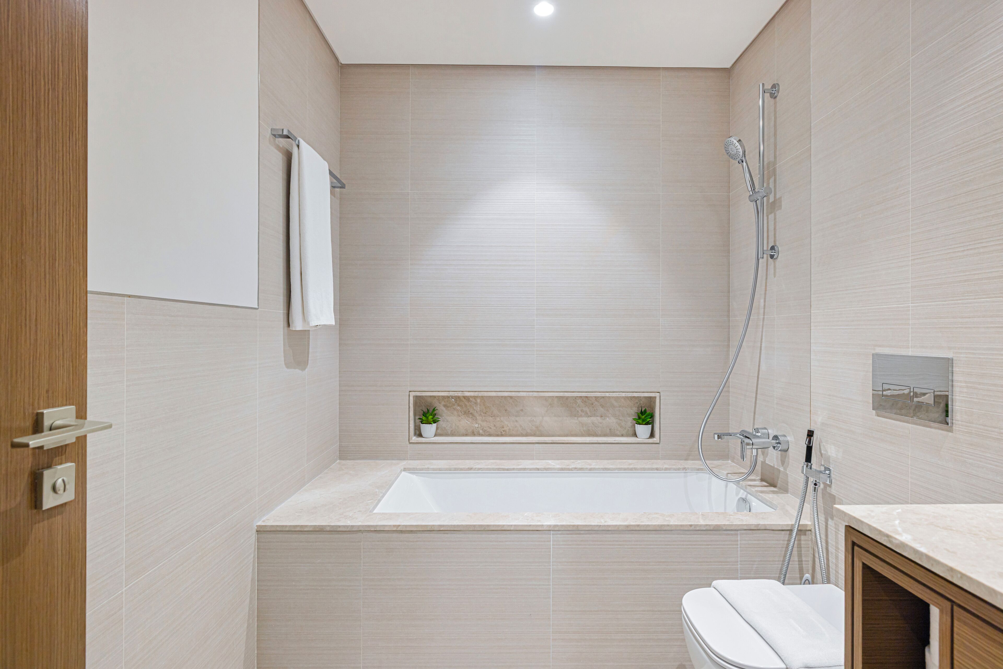 A modern bathroom with a bathtub, a toilet, and a shower area.