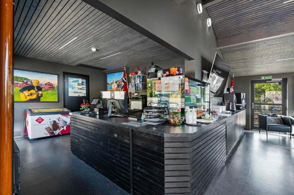A modern reception area with a counter, seating, and a view of the outdoors.