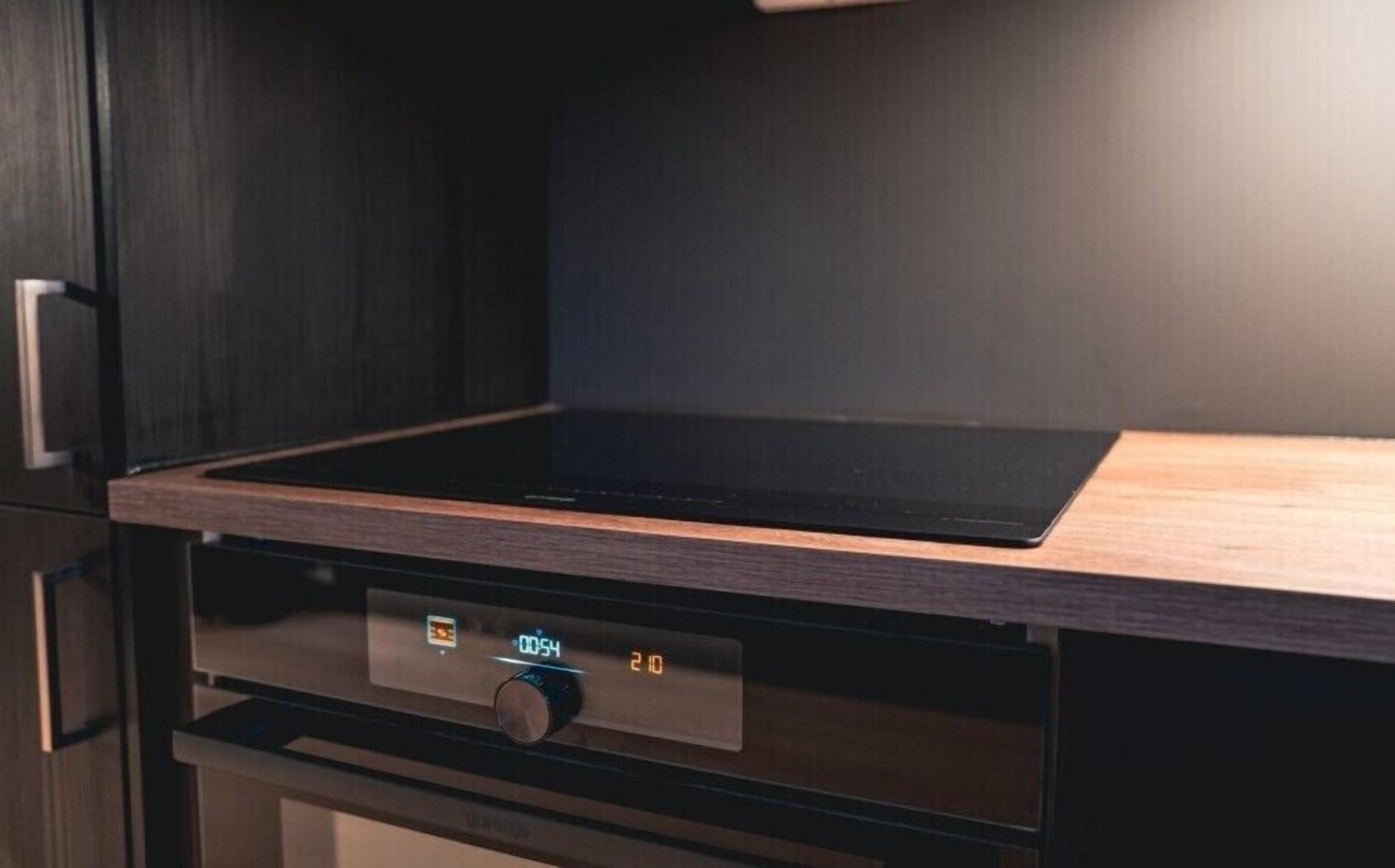 Een keuken met een digitaal bedieningspaneel en een houten aanrecht.