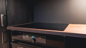Een keuken met een digitaal bedieningspaneel en een houten aanrecht.