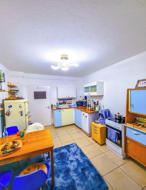 A compact kitchen with a refrigerator, stove, and cabinets.