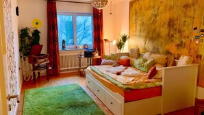 A bedroom with a bed, a desk, a radiator, a window, and a green rug. - Room 'Sternenzimmer' with Wi-Fi (KASSEL)