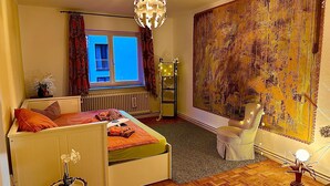 A bedroom with a bed, a window, a radiator, a lamp, and a painting on the wall. - Room 'Sternenzimmer' with Wi-Fi (KASSEL)