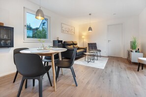 Un salon moderne comprenant un coin repas, un canapé, une table basse et une lampe.