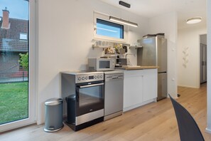 A modern kitchen with built-in appliances, a window, and a view of the outside.