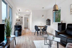 Una sala moderna con un sofá, una mesa de centro y un comedor con sillas y una mesa.