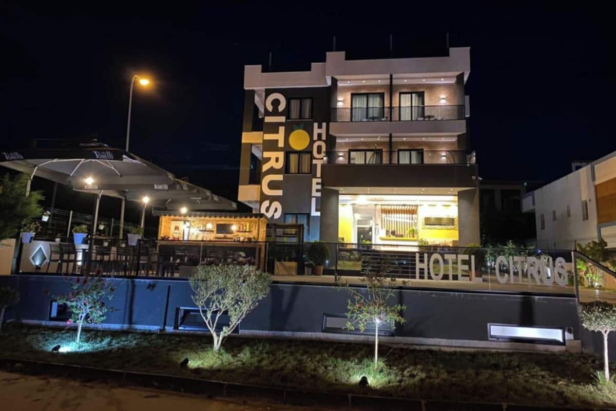 A modern hotel with a prominent 'CITRUS' sign, outdoor seating, and a well-lit entrance.
