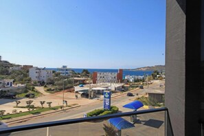 A coastal town with buildings, a road, and a clear view of the sea. - Hotel Citrus (Ksamil)