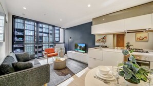 A modern apartment with a living area, kitchen, and dining space.