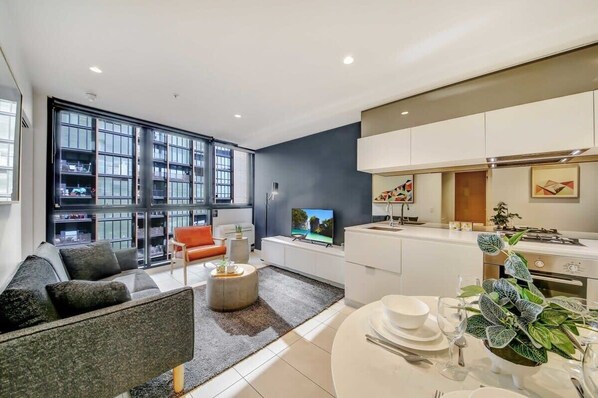 A modern apartment with a living area, kitchen, and dining space.