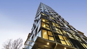 A modern high-rise building with a unique angular facade and large windows.