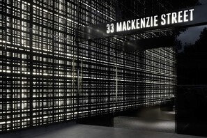 Fachada moderna de un edificio con un letrero digital que muestra Mackenzie Street.