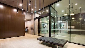 Een modern interieur met een bank, glazen wanden en hangende lampen.