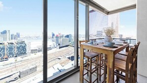 A high-rise apartment with a large floor-to-ceiling window offering a city view.