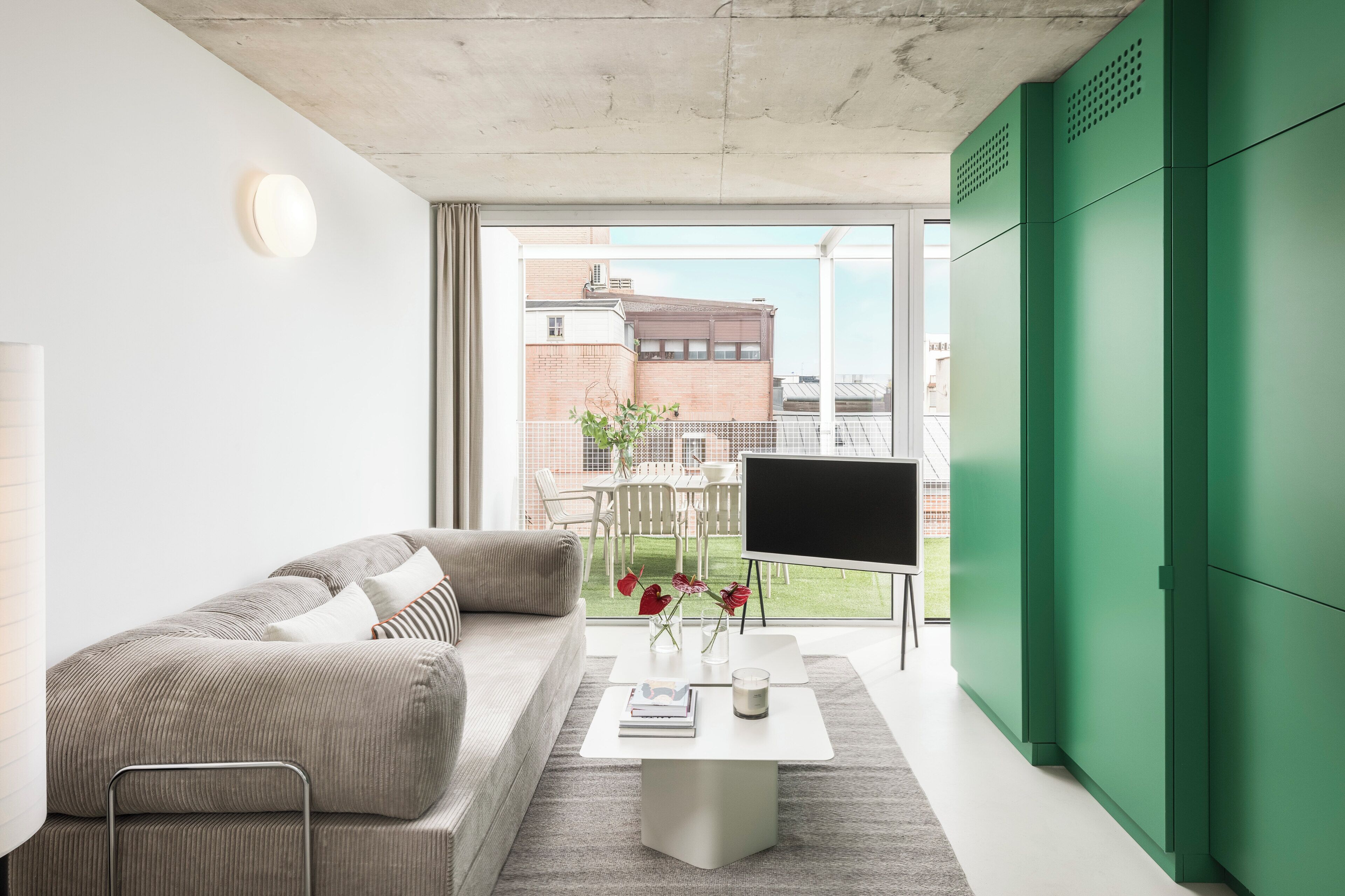 Una sala de estar moderna con un sofá, una mesa de centro y un televisor de pantalla plana.