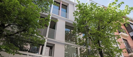 Un edificio de varios pisos con balcones, ventanas amplias y un estilo arquitectónico moderno.