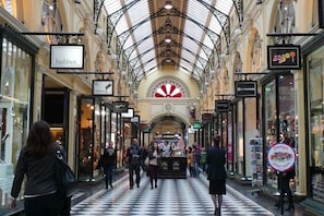 A shopping mall with a checkered floor and ornate ceiling.