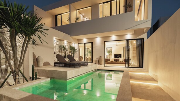A modern house with a swimming pool, outdoor seating, and a well-lit interior. - Pala House by Alfred in Bali (Pecatu)