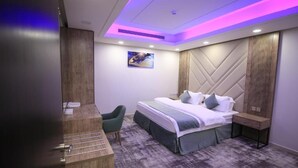 Ein modernes Hotelzimmer mit Bett, Schreibtisch und Stuhl.