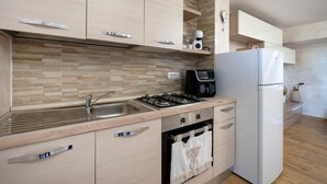 Una cocina equipada con fregadero, estufa, horno y refrigerador.