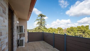 Un balcón con vistas a árboles y un cielo despejado.