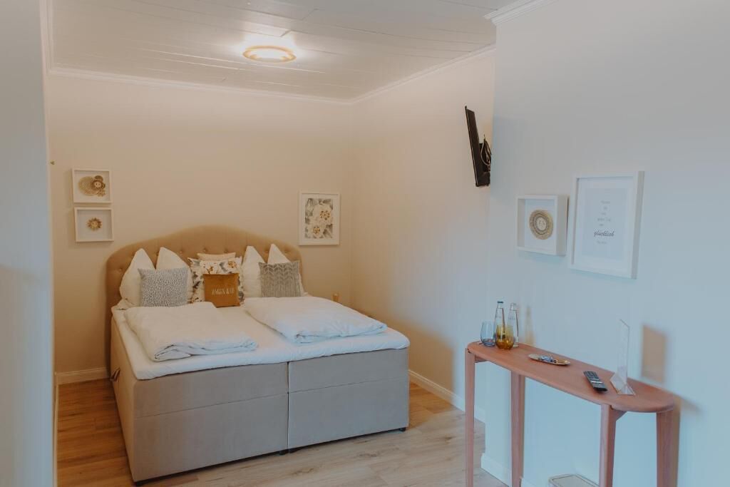 Un dormitorio con cama, mesita de noche y decoración en la pared.
