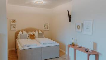 Un dormitorio con cama, mesita de noche y decoración en la pared.