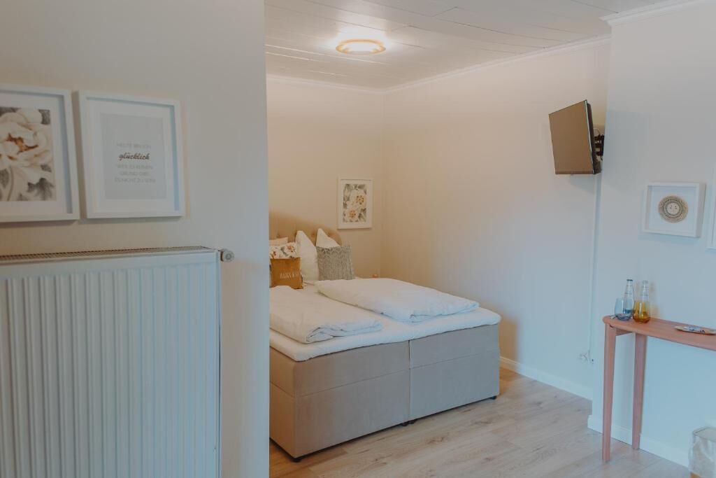 Une chambre à coucher avec un lit, une table de chevet et un radiateur.