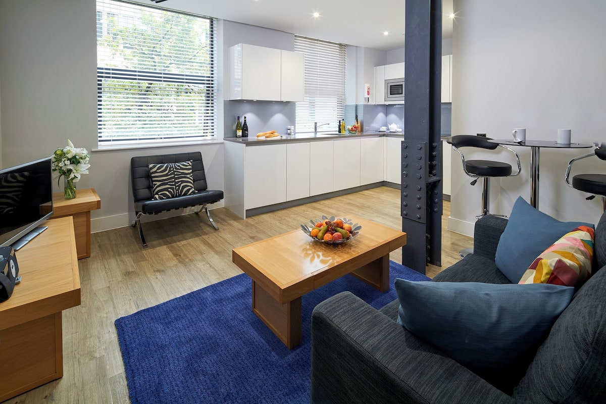 A modern living room with a sofa, coffee table, and a TV.