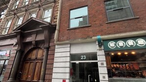 A building with a large wooden entrance, a storefront with meat products, and a number 23 sign. - National at Tower Bridge (London)