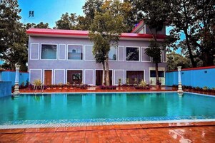 A two-story building with a swimming pool in front.