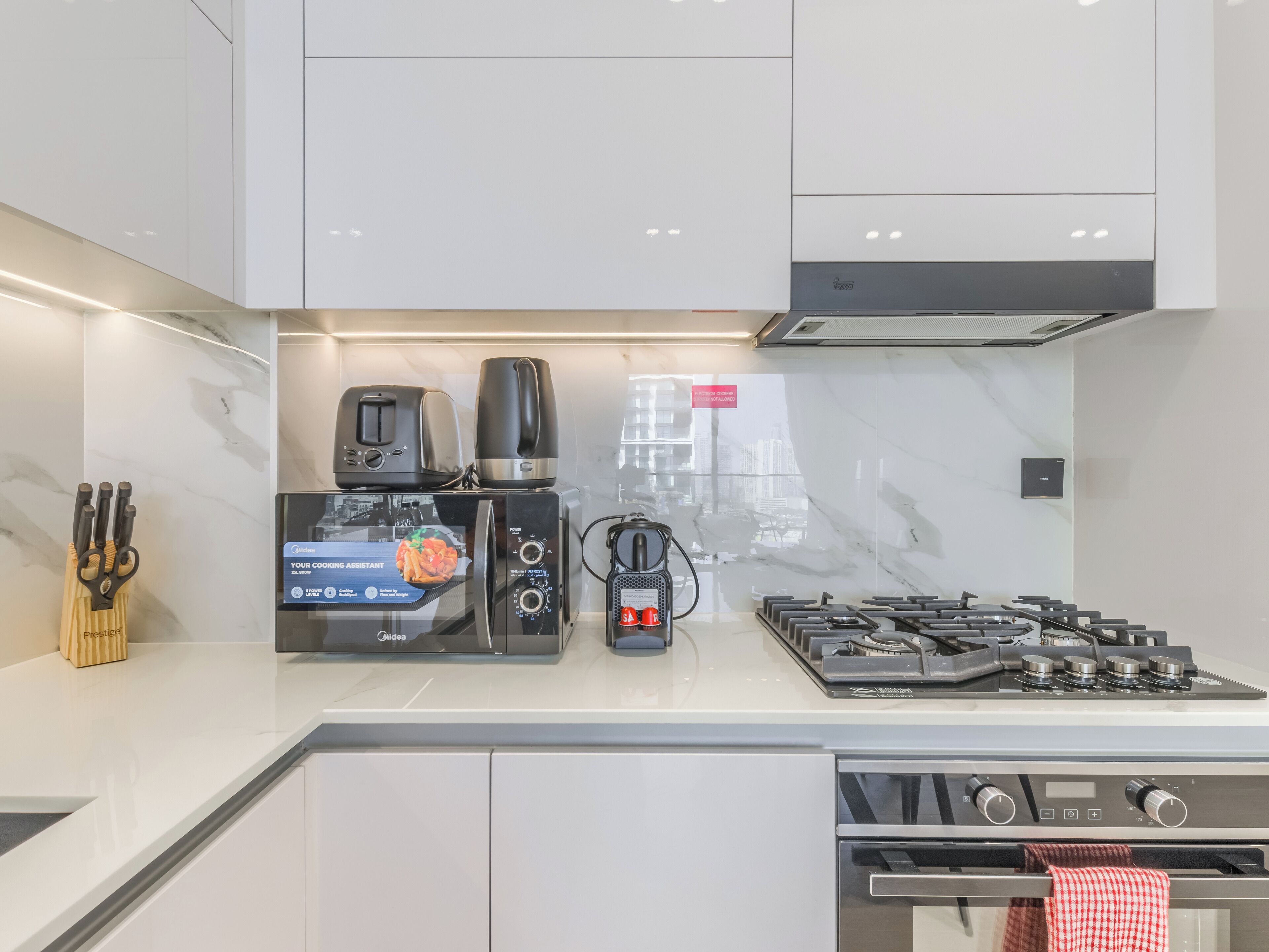 A modern kitchen with a built-in oven, a coffee maker, and a toaster.
